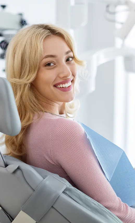 Smiling woman in dental chair at Colonia Dental Associates