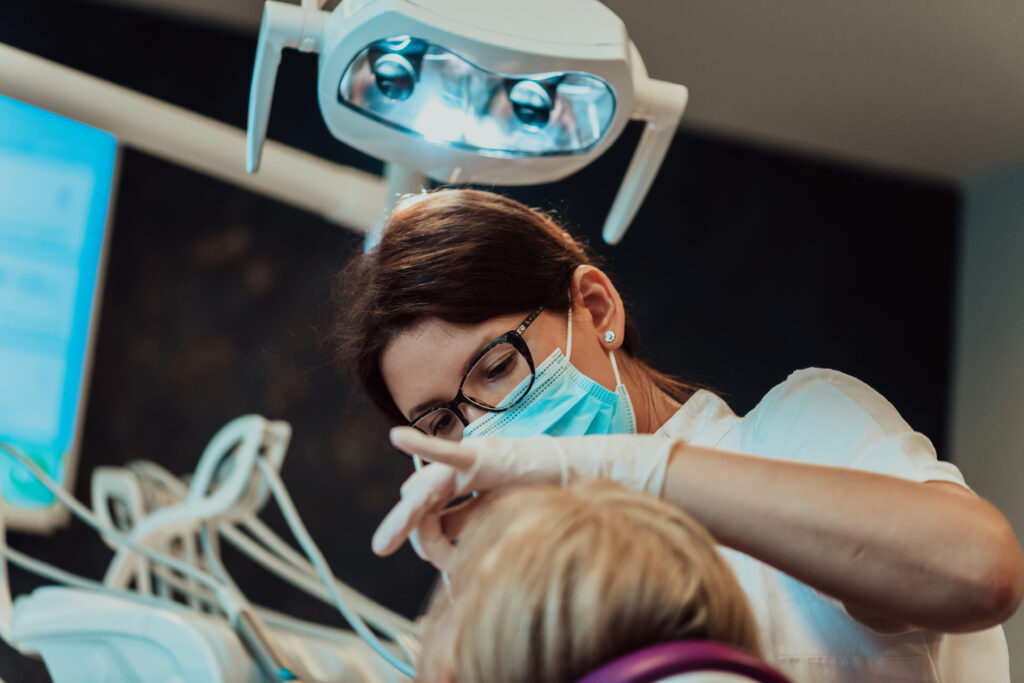 A dentist in a modern dental practice performs jaw surgery on an elderly patient